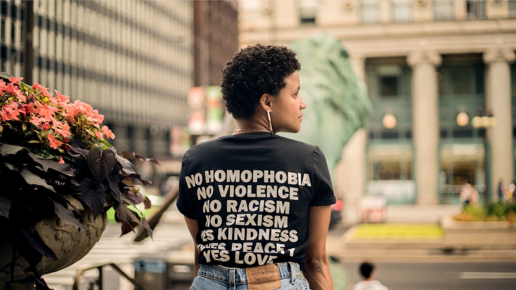 Farbige Frau mit Shirt für anti-diskriminierende Gesellschaft in der Stadt